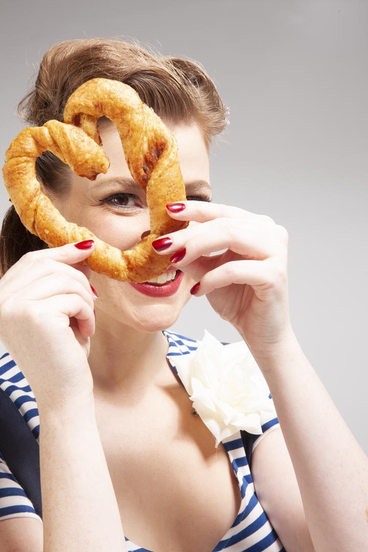 Frau blickt durch eine Brezel