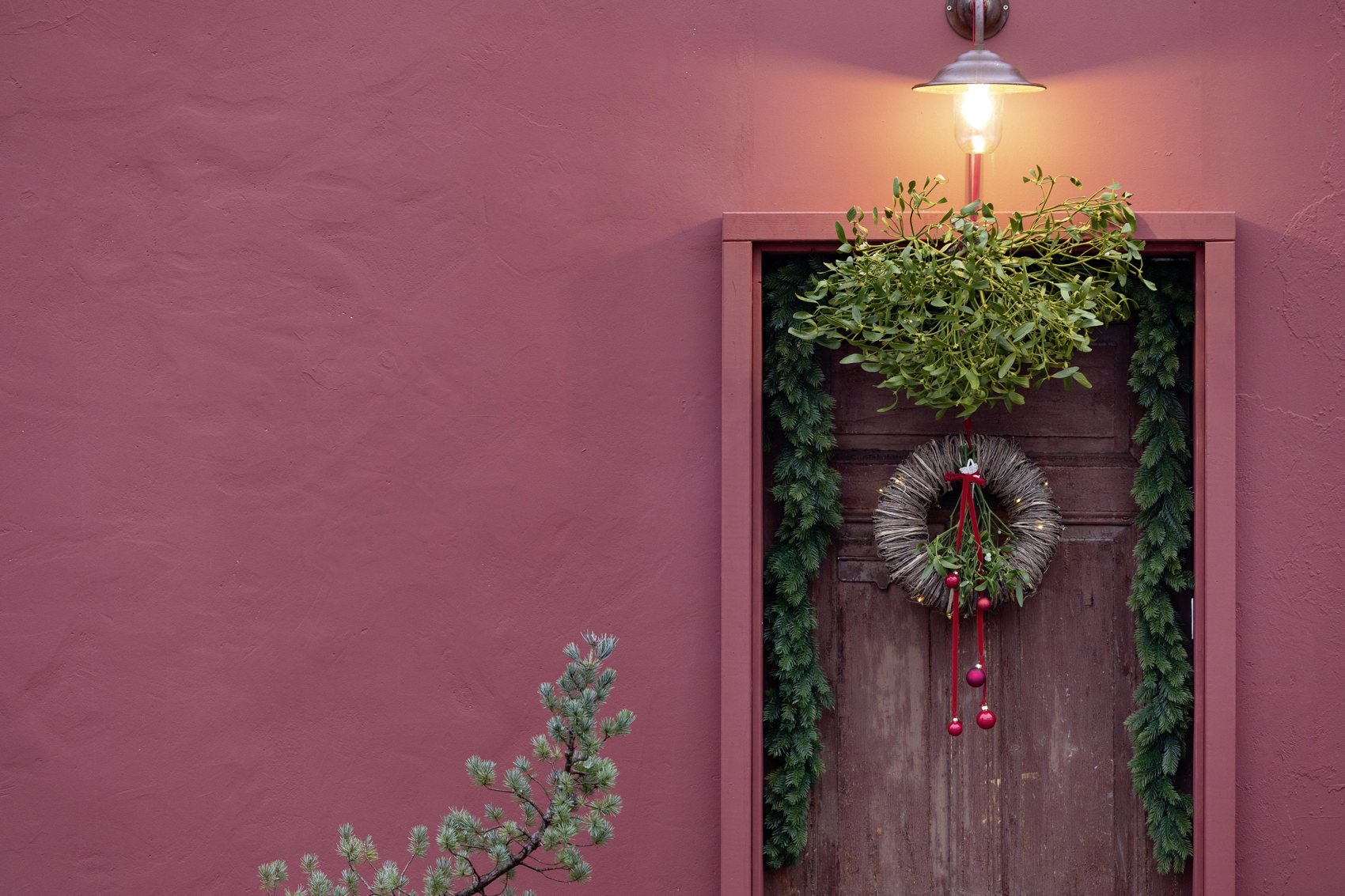 Mistelkranz an pinkfarbener Hauswand